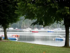 Éguzon lake - Chambon lake: lawn, trees along the water, stretch of water and boats