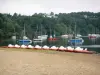 Éguzon lake - Chambon lake: Chambon beach (in the town of Éguzon-Chantômeme), pedal boats, stretch of water with boats, and wooded bank