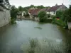Essoyes - Fluss (Ource) mit Wasserpflanzen (Schilfrohr) und Häusern des Dorfes am Rande des Wassers