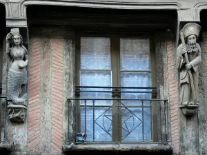 La Ferté-Bernard - Esculturas en la fachada de una casa antigua con paredes de madera