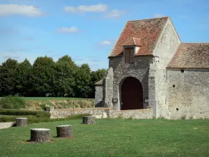 Fief des Epoisses stronghold - Entrance to the old medieval fortified farm, lawns and trees; in the town of Bombon