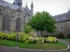 Fougères - Église Saint-Léonard, Hôtel de Ville et jardin public avec arbre, lampadaire, pelouse et fleurs