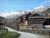 La Foux d'Allos - Strasse und Wohnhäuser der Skistation Val d'Allos 1800, Berge mit schneebedeckten Gipfeln im Hintergrund