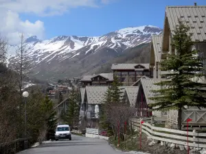 La Foux d'Allos - Route, chalets de la station de ski de Val d'Allos 1800, arbres et montagnes aux cimes enneigées