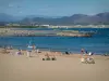 Fréjus - Fréjus-Plage: Sandstrand mit Feriengästen, Mittelmeer, Felsen, Golf von Fréjus und Hügel im Hintergrund