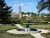 Fumel - Fountain of the French-style formal garden of the château with a view of the bell tower of the Saint-Antoine church