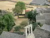 La Garde-Guérin - Bell tower of the Saint-Michel church, roofs of houses in the medieval village, trees and meadows