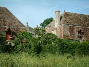 Gärten des Priorats Notre-Dame d'Orsan - Gebäude des ehemaligen Klosters mit Pflanzen und Bäumen