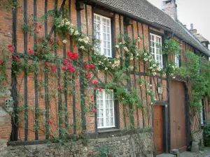 Gerberoy - Maison à colombages et briques avec des rosiers grimpants (roses rouges et jaunes)