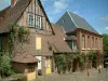 Gerberoy - Maisons en brique (mairie et musée) avec des rosiers grimpants (roses rouges)