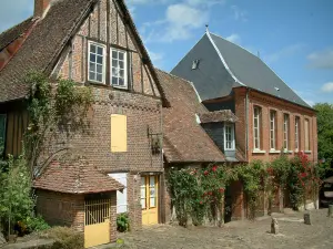 Gerberoy - Maisons en brique (mairie et musée) avec des rosiers grimpants (roses rouges)