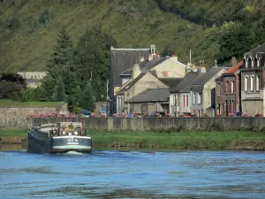 Givet - Vallei van de Maas, in het Parc Naturel Regional des Ardennes: schuit varen op de rivier de Maas, en huizen van de stad