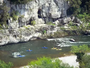 Gorges de l'Ardèche - Pratique du kayak sur les eaux de l'Ardèche ; paroi rocheuse dominant la rivière