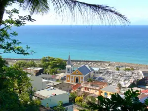 Grand'Rivière - View of the church of Saint Catherine, the cemetery, the port, the village rooftops and the Atlantic Ocean