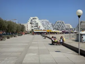 La Grande-Motte - Promenade decorated with benches and lampposts, pyramid-shaped buildings of the seaside resort