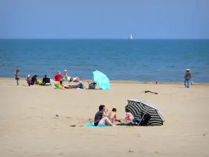 Gruissan - Gruissan-Plage, dans le Parc Naturel Régional de la Narbonnaise en Méditerranée : vacanciers se reposant sur la plage de sable, au bord de la mer Méditerranée