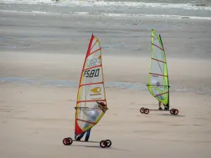 Hardelot-Plage - Opal Coast: sandy beach with two people speed-sailing (windsurfing boards with wheels), gulls and the Channel (sea) in background; in the Regional Nature Park of Opal Capes and Marshes