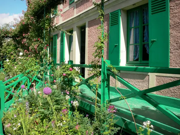 Huis en tuinen van Claude Monet - Roze huis met groene luiken van Monet en zijn omgeving versierd met bloemen in Giverny