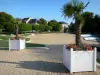 L'Isle-Adam - Municipal river beach (sandy beach), swimming pool, and potted palm trees in the foreground