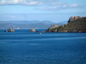 Isola di Porquerolles - Mediterraneo mare, rocce, costa selvaggia dell'isola, la costa e le colline delle colline Maures in lontananza, le nuvole nel cielo
