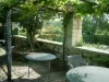 Jardins du prieuré Notre-Dame d'Orsan - Tables et chaises sous pergola, potager et arbres en arrière-plan