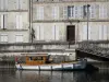 Jarnac - Bateau en bois amarré au quai, fleuve Charente et façades de maisons