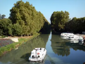 Kanaal van Garonne - Boten varen het kanaal van de Garonne (Canal de Garonne), afgemeerde boten, en vliegtuigen (bomen) aan de rand van het water, in Damazan