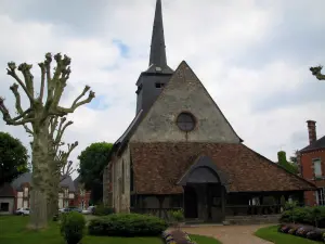 Kirche von Souvigny-en-Sologne - Kirche und ihr caquetoir, Bäume, Häuser des Dorfes und bewölkter Himmel, in der Sologne