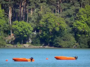 Lago di Aydat - Due piccole barche che galleggiano sul lago e gli alberi lungo l'acqua nel Parco Naturale Regionale dei Vulcani d'Alvernia