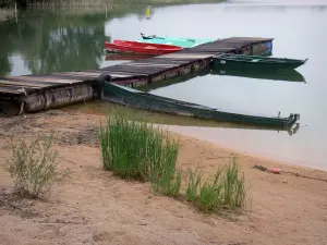 Lago de Chalain - Playa de arena, cañas, barcos amarrados a un muelle y un lago