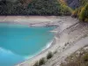 Lago de Chambon - La retención de agua turquesa y la costa bordeada de árboles, en el valle de la Romanche