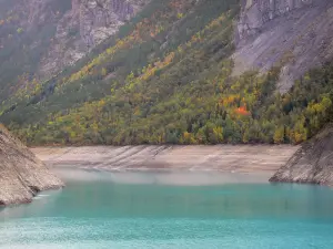 Lago de Chambon - La retención de agua turquesa y la costa bordeada de árboles, en el valle de la Romanche