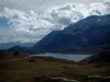 Lago del Monte Cenis - Los pastos, lago (depósito de agua), montaña (Mont Cenis) y las nubes en el cielo, en Haute-Maurienne (zona periférica del Parque Nacional de la Vanoise)