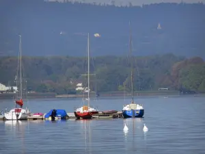 Lago de Nantua - Lago, embarcaciones amarradas a un pontón, y en la orilla arbolada, en el Haut-Bugey