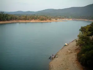 Lago de Saint-Cassien - Pescador, lago, costa, los árboles y las colinas boscosas