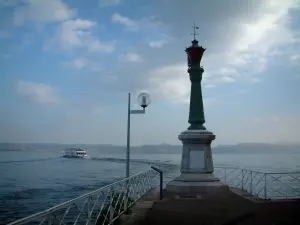 Lake Geneva - Évian-les-Bains shore, lighthouse, lamppost, lake with a boat, Swiss shore and clouds in the sky