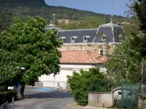 Lamalou-les-Bains - Bâtiment abritant le Casino de la station thermale, arbres et colline