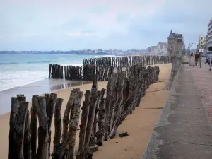 Landscapes of the Brittany coast - Emerald Coast: beach with wooden pickets, walk, building and houses alongside the beach and the sea, in Saint-Malo