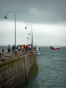 Landscapes of the Brittany coast - Cancale: pier decorated with lampposts, fishing boats on the sea and turbulent sky