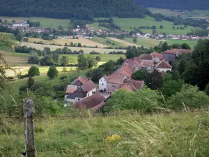 Landscapes of the Doubs - Fence of a meadow in foreground, houses of a village, fields, prairies and trees