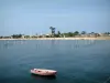 Landscapes of the Gironde - Boat floating on the water with a view of the seaside resort of Cap-Ferret 
