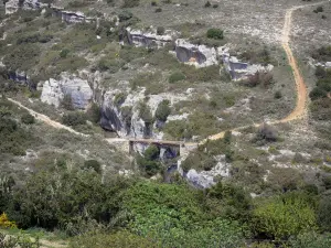 Landscapes of Languedoc - Road leading to a bridge, cliff, shrubs and trees, in the Upper Languedoc Regional Nature Park