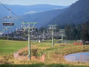 Landscapes of the Puy-de-Dôme - Auvergne Volcanic Regional Nature Park: chairlift (ski lift) of the ski resort of Le Mont-Dore, grass and trees in the Massif du Sancy mountains (Monts Dore)