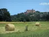 Landscapes of the Quercy - Castelnau-Bretenoux castle, houses, trees and field with straw bales