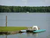 Landschaften der Sarthe - See von Sillé, im Regionalen Naturpark Normandie-Maine: Wasserfläche, angemachte Tretboote, und Wald von Sillé im Hintergrund