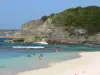 Landschappen van Guadeloupe - Laborde baai met strand op het eiland Grande - Terre, in het centrum van Anse - Bertrand : zandstrand en zwemmers af te koelen in het turquoise water van de zee, met uitzicht op de kliffen