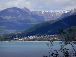 Landschappen van de Hautes-Alpes - Serre-Ponçon (vasthouden van water), dorp Savines-the-meer en de bergen, takken van een boom op de voorgrond, in het Parc National des Ecrins