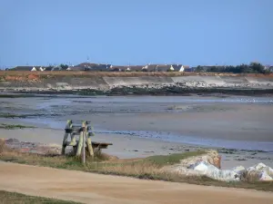 Landschappen van Normandië - Kust van het schiereiland Cotentin: bankje met uitzicht op het strand, daken van huizen op de achtergrond