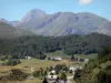 Landschappen van de Pyreneeën - Huizen, omringd door weilanden, bossen en bergen waaronder de top van de Pic du Midi de Bigorre op de achtergrond