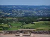 Landschappen van de Quercy - Stenen bank met uitzicht op de velden, weiden, huizen, bomen en kleine heuvels